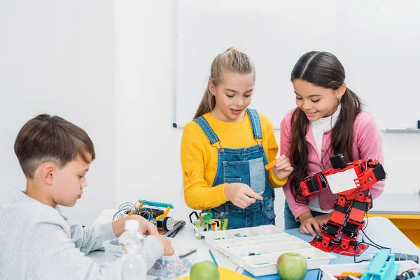 Schoolchildren programming robot together during STEM educational class — Stock Photo