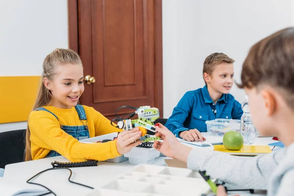 Schüler gibt Schulmädchen Robotermodell bei Stammprogrammierstunde — Stockfoto