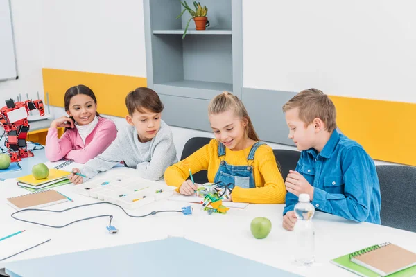 Enfants heureux travaillant ensemble sur le projet STEM en classe — Photo de stock