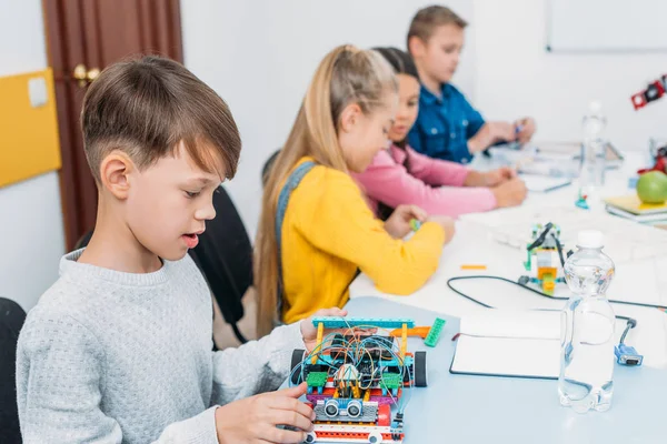 Niños enfocados trabajando juntos en el proyecto STEM en clase - foto de stock