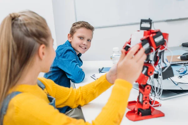 Escolares programando robot juntos durante la clase de educación STEM - foto de stock