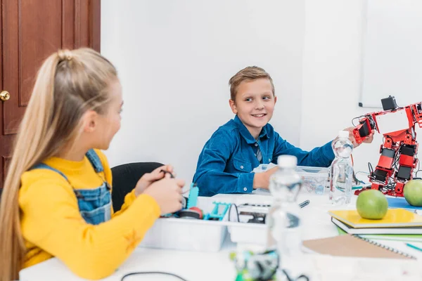 Enfants heureux travaillant ensemble sur le projet STEM en classe — Photo de stock