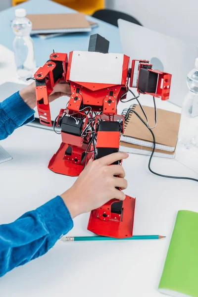 Visão cortada de estudante brincando com modelo de robô na classe educacional STEM — Fotografia de Stock