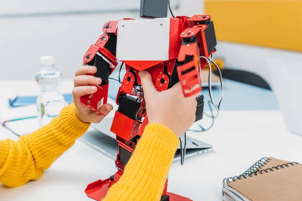 Visão cortada de estudante brincando com modelo de robô na classe educacional STEM — Fotografia de Stock