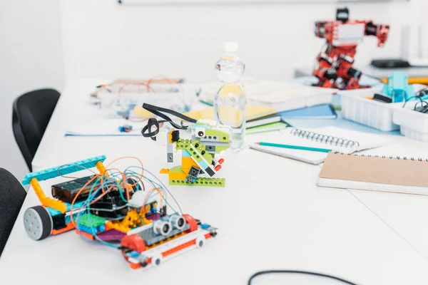 Modelos de robots hechos a mano y útiles escolares en la mesa en clase STEM - foto de stock