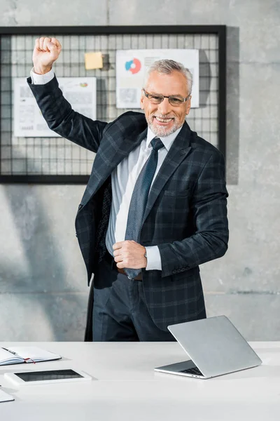 Glücklich gutaussehender Geschäftsmann mittleren Alters gestikuliert und schaut im Büro in die Kamera — Stockfoto