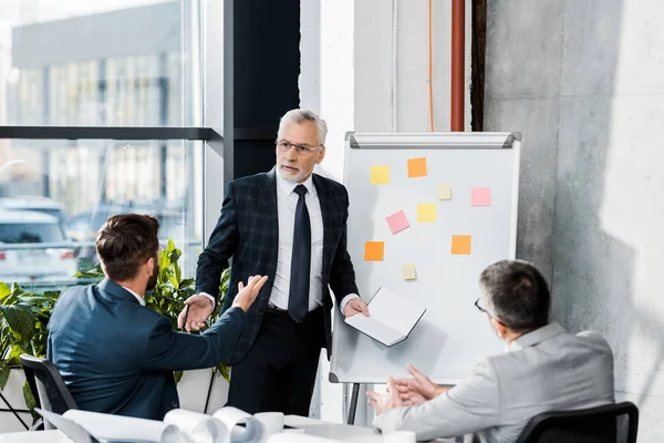 Guapos hombres de negocios discusión durante la reunión en la oficina - foto de stock