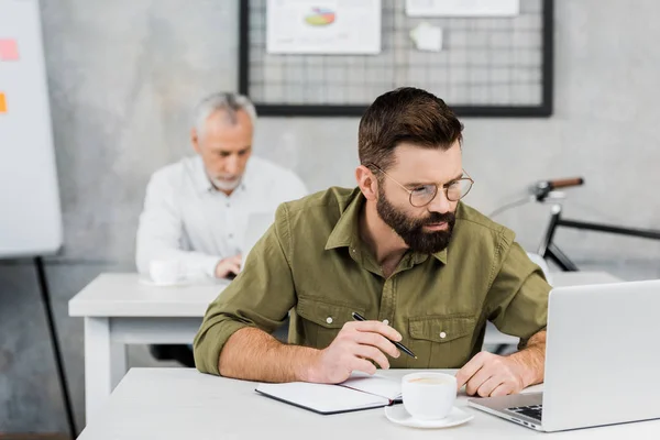 Dos hombres de negocios guapos trabajando en la oficina - foto de stock