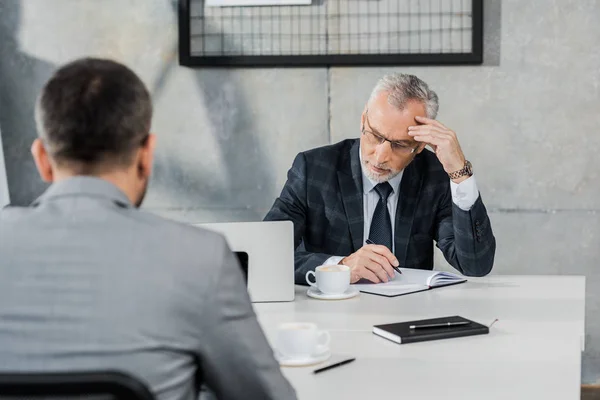 Homens de negócios pensivos sentados à mesa no escritório no escritório — Fotografia de Stock