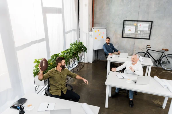 Высокий угол зрения привлекательных бизнесменов, веселящихся в офисе — стоковое фото