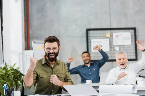 Glückliche gutaussehende Geschäftsleute zeigen Ja-Geste im Amt — Stockfoto