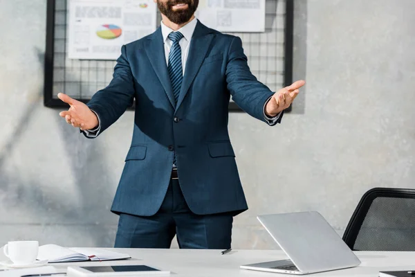 Cropped image of businessman gesturing and standing with open arms in office — Stock Photo