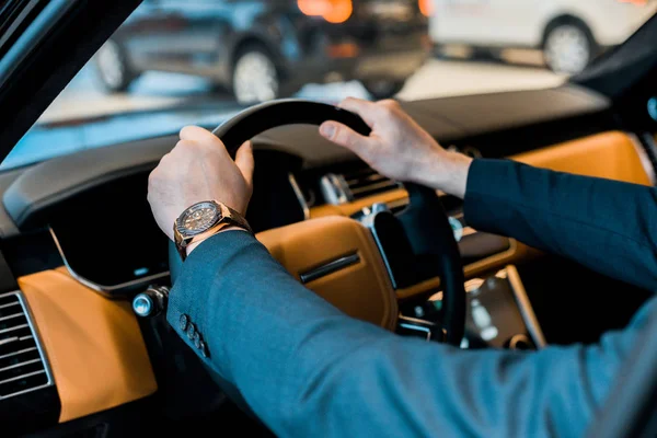 Imagem cortada de homem de negócios com relógio de luxo sentado no automóvel — Fotografia de Stock