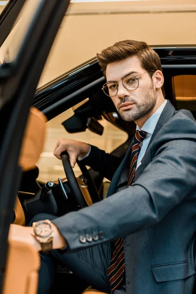 Seriöser Geschäftsmann schließt Tür, während er im Auto sitzt — Stockfoto