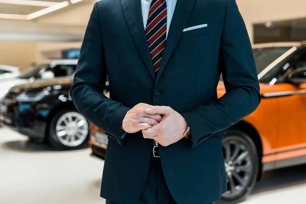 Immagine ritagliata di uomo d'affari in abito formale in posa al salone di concessionaria — Foto stock