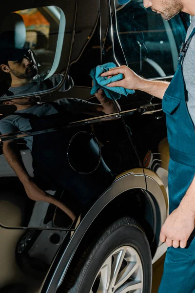 Vista parziale di auto meccanico pulizia auto con straccio in officina di riparazione auto — Foto stock