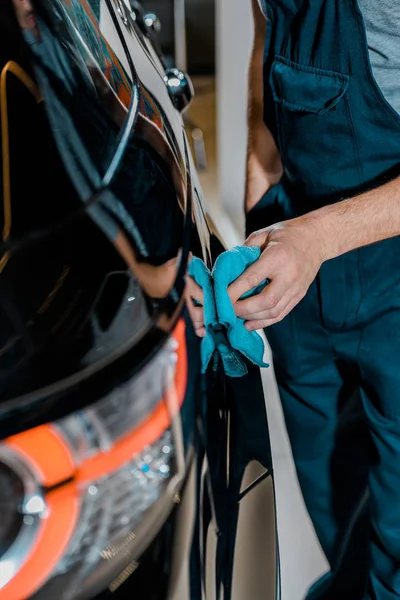 Vista parziale di auto meccanico pulizia auto con straccio in officina di riparazione auto — Foto stock