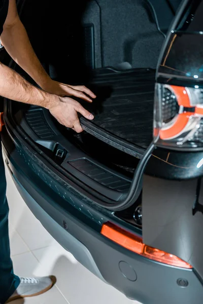 Partial view of auto mechanic checking car trunk at auto repair shop — Stock Photo
