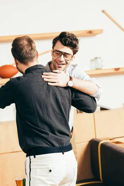 Jovens amigos cumprimentando uns aos outros no café — Fotografia de Stock