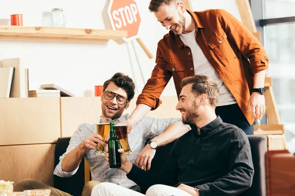 Jeunes amis souriants clinking boissons tout en se reposant dans le café ensemble — Photo de stock