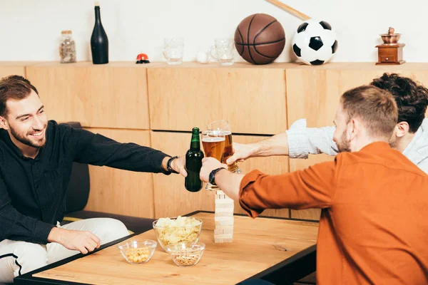 Amigos tintineando bebidas mientras descansan en la cafetería juntos - foto de stock