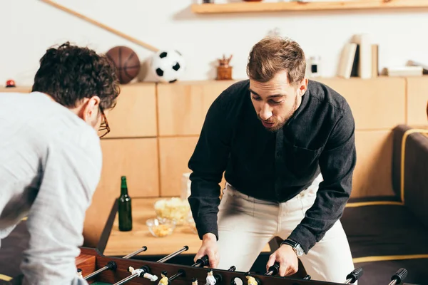Молоді друзі грають у настільний футбол у кафе — стокове фото