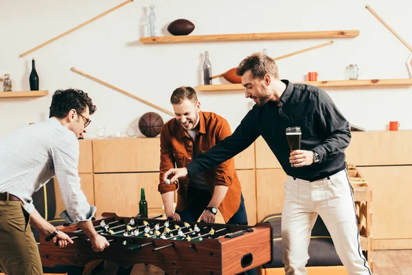 Young men playing table soccer together in cafe — Stock Photo