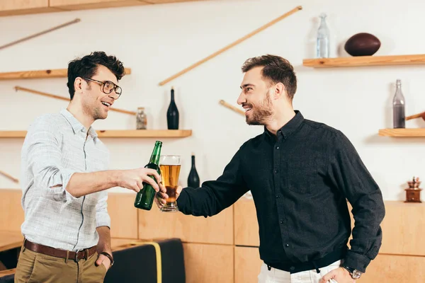 Portrait of friends clinking drinks and looking at each other in cafe — Stock Photo