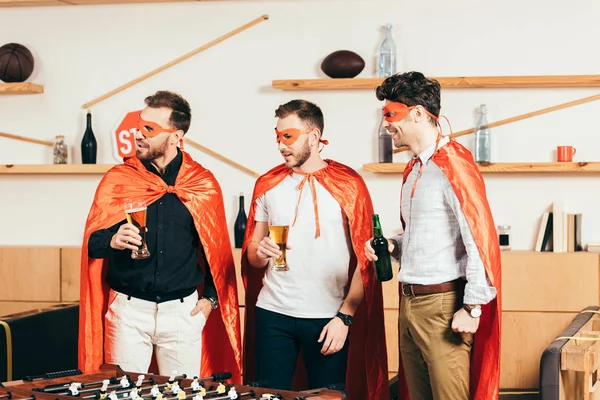 Porträt junger Männer in Superheldenkostümen mit Bier im Café — Stockfoto