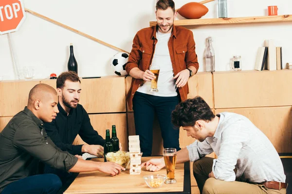 Amigos multiétnicos jugando bloques juego de madera en la cafetería - foto de stock