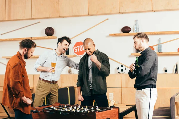 Junge Freunde spielen gemeinsam Tischfußball im Café — Stockfoto