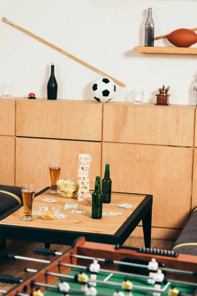 Vista de cerca de la cerveza, aperitivos y bloques juego de madera en la mesa en la cafetería - foto de stock