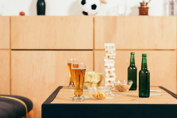 Закрытый вид на пиво, закуски и деревянные блоки на столешнице в кафе — стоковое фото