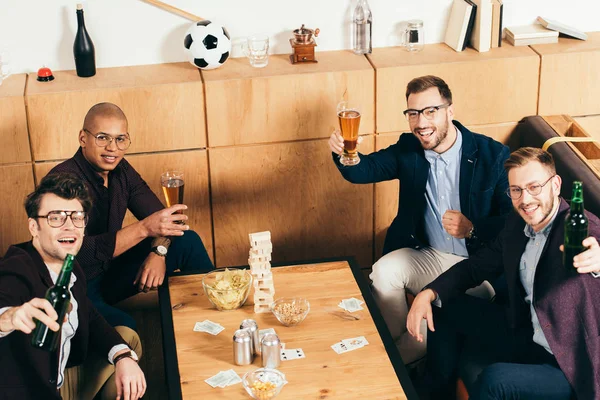 Vista de ángulo alto de sonriente equipo de negocios multiétnicos con cerveza descansando en la cafetería juntos - foto de stock