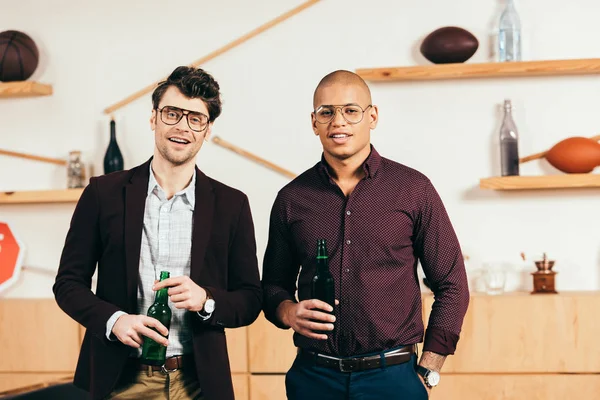 Retrato de jovens empresários multiculturais com cerveja olhando para a câmera no café — Fotografia de Stock