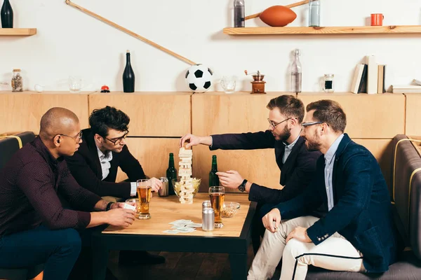 Multiethnische Geschäftsleute mit Bier spielen Holzklötzchen-Spiel im Café — Stockfoto