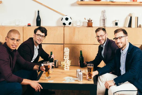 Young multicultural businessmen with beer looking at camera spending time in cafe — Stock Photo