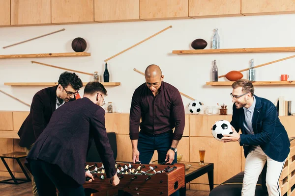 Multirassische Geschäftsleute spielen Tischfußball, während sie sich im Café ausruhen — Stockfoto