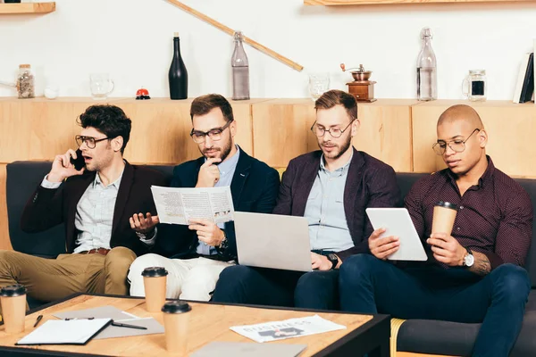 Retrato de jóvenes colegas de negocios multirraciales concentrados en la cafetería - foto de stock