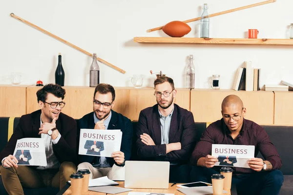 Портрет молодых мультикультурных бизнесменов с газетами в кафе — стоковое фото