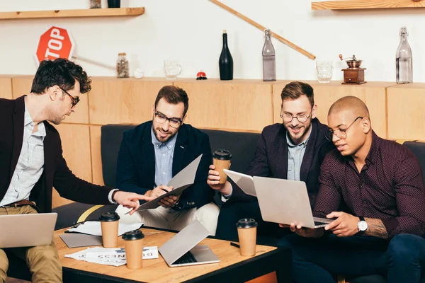 Empresarios multiétnicos que trabajan en el proyecto empresarial en la cafetería - foto de stock