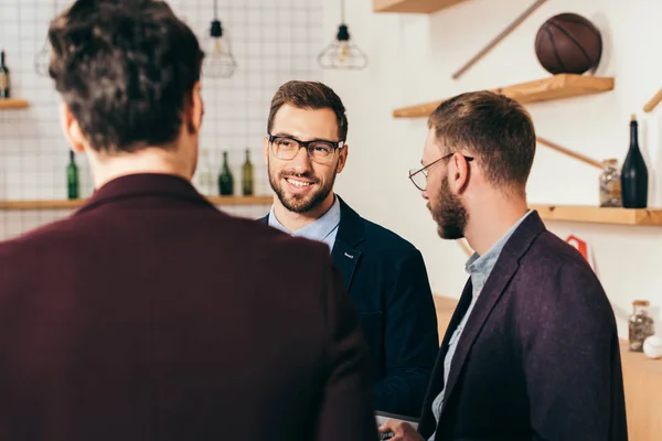 Selektive Fokussierung eines lächelnden Geschäftsmannes auf einen Kollegen im Café — Stockfoto