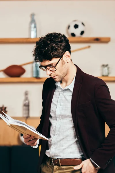 Vue latérale du livre élégant de lecture d'homme d'affaires dans le café — Photo de stock