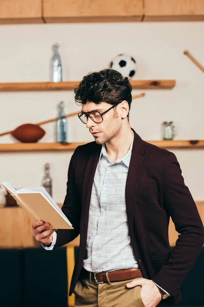 Вид збоку стильний бізнесмен читає книгу в кафе — стокове фото