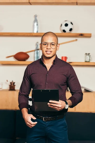 Portrait d'un homme d'affaires afro-américain en lunettes avec tablette à la main regardant la caméra dans un café — Photo de stock