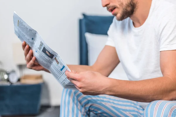 Cropped image of man reading newspaper in bed in morning at home — Stock Photo