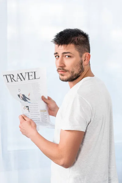 Handsome man holding travel newspaper in morning at home and looking at camera — Stock Photo