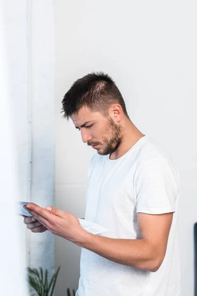 Handsome man reading newspaper in bedroom in morning — Stock Photo