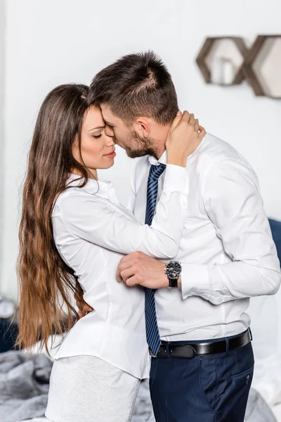 Пара целуется утром в спальне перед работой — стоковое фото