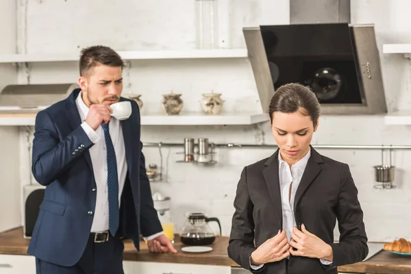 Novio bebiendo café y mirando a la novia por la mañana en la cocina, concepto de igualdad de género - foto de stock